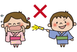 人に向けて花火を向ける男の子