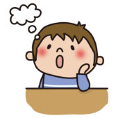 机に肘をついて想像する子供（男の子）