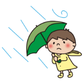 台風の強い雨風に吹かれている子供（男の子）