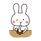 お雑煮のお餅を食べている白いうさぎ