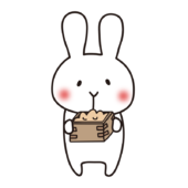 節分の豆を食べたそうに見つめる白いうさぎ