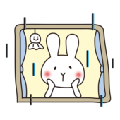 雨の日に窓から外を見つめる白いうさぎ