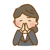 両手を合わせてお願いしているゆるくて可愛いスーツの女性