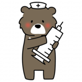 大きな注射器を持っているナースキャップをかぶったクマ